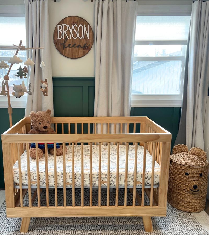 Picture of a modern oak crib, woodland themed nursery mobile, bear laundry basket 