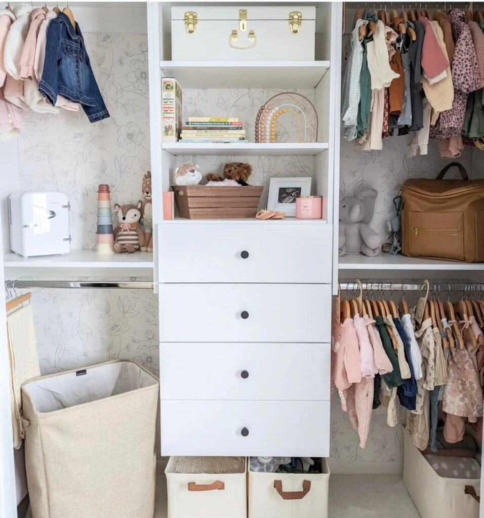 Organized nursery closet with drawers, shelves, hanging clothes, and laundry basket