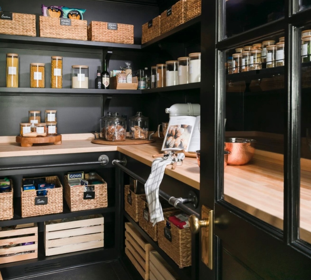 A pantry organized with wicker bins, crates, and jars.