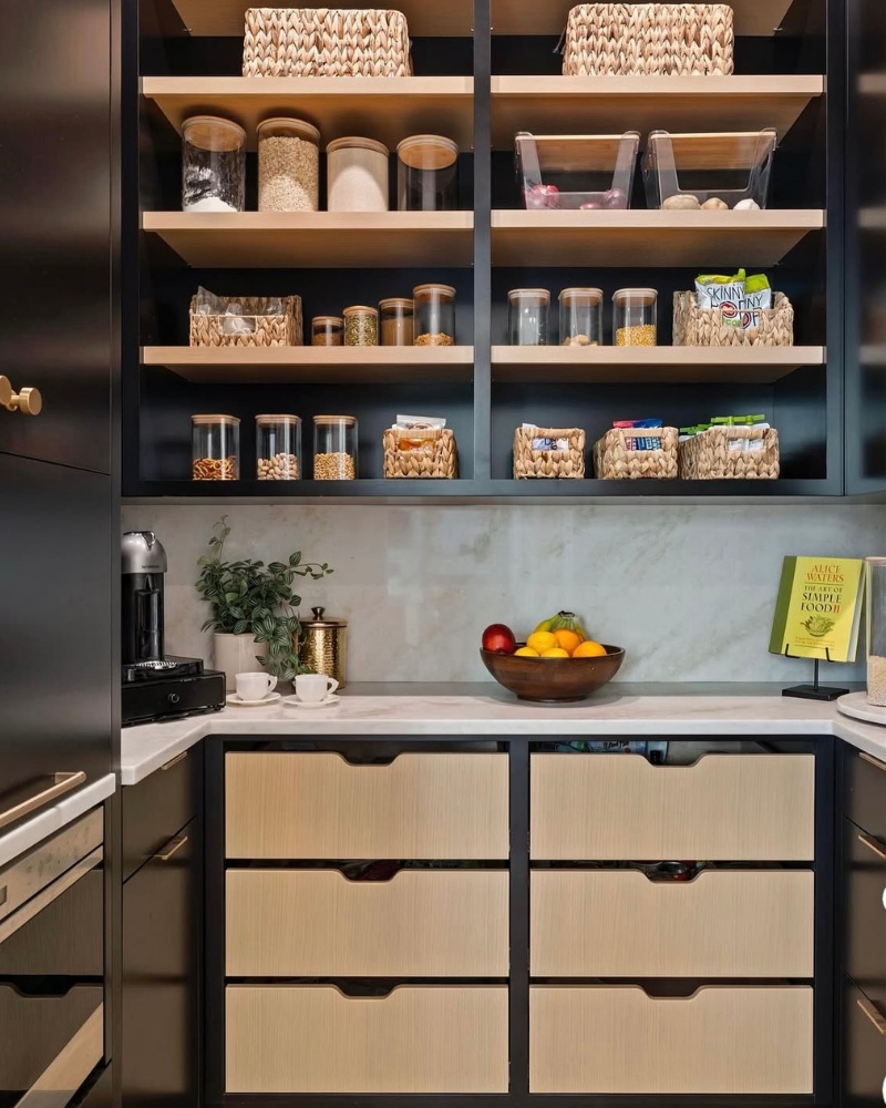 Large black pantry with shelving, wicker baskets, and bamboo glass containers.