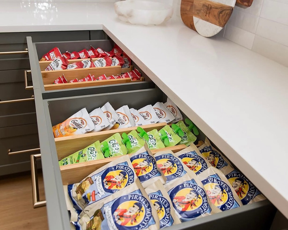 A pantry drawer with pantry snacks inside organized with wood drawer dividers.