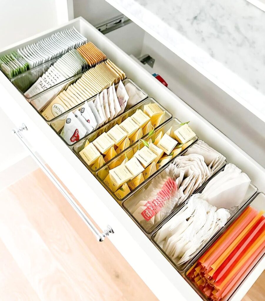 A pantry drawer with items organized by category with plastic drawer organizers