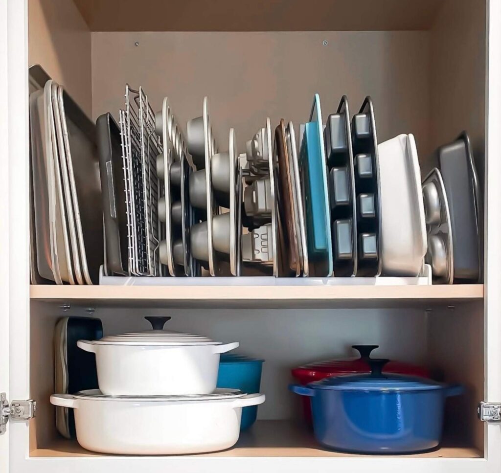 Baking trays, pans, and pots organized in a kitchen cabinet