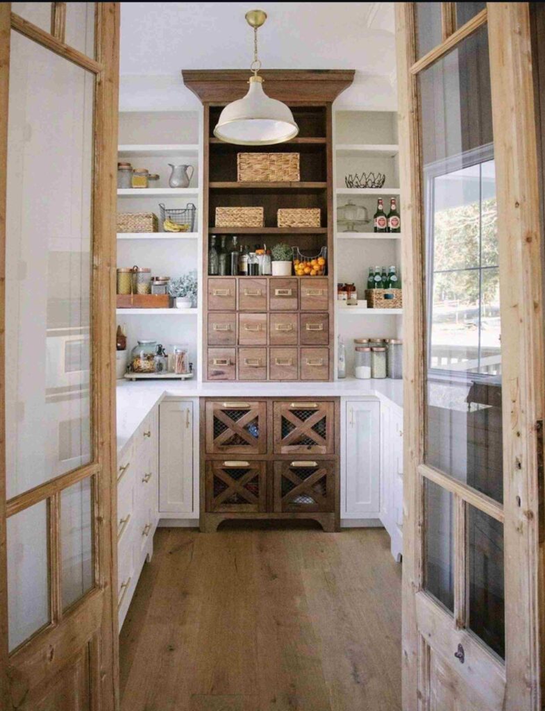 Farmhouse style pantry with small pantry mail drawers, white shelving, woven baskets, mesh drawers, jars, and white cabinets.