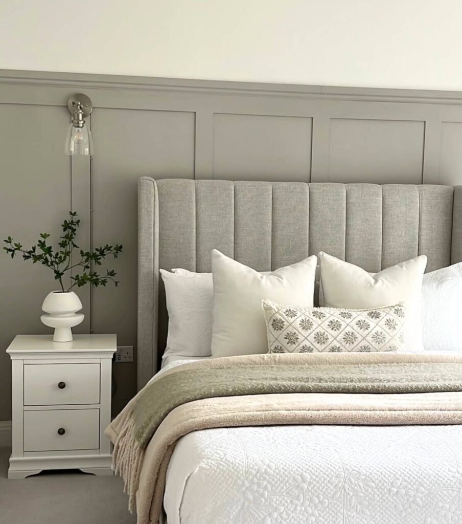 Bedroom with lighting on the wall and bed in the photo with nightstand