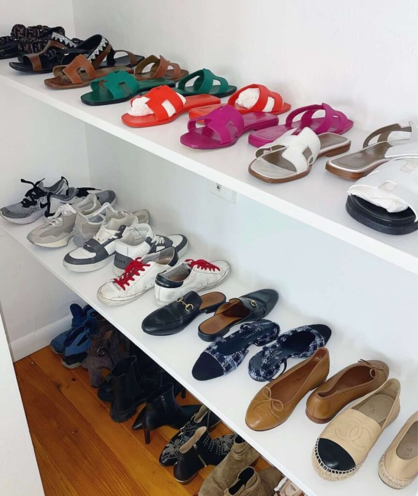 Shoe storage on the bottom of a closet with white floating wall shelves 