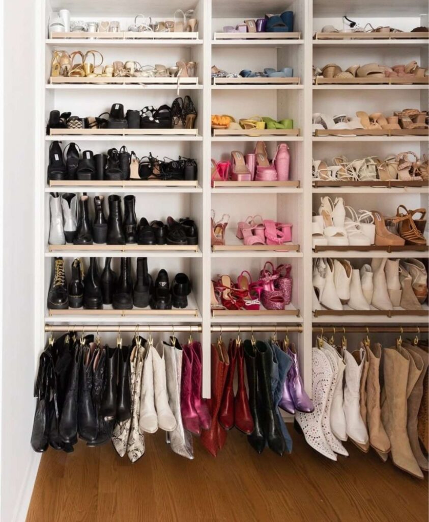 Walk-in closet with shoes stored by color and boots hung using a rod