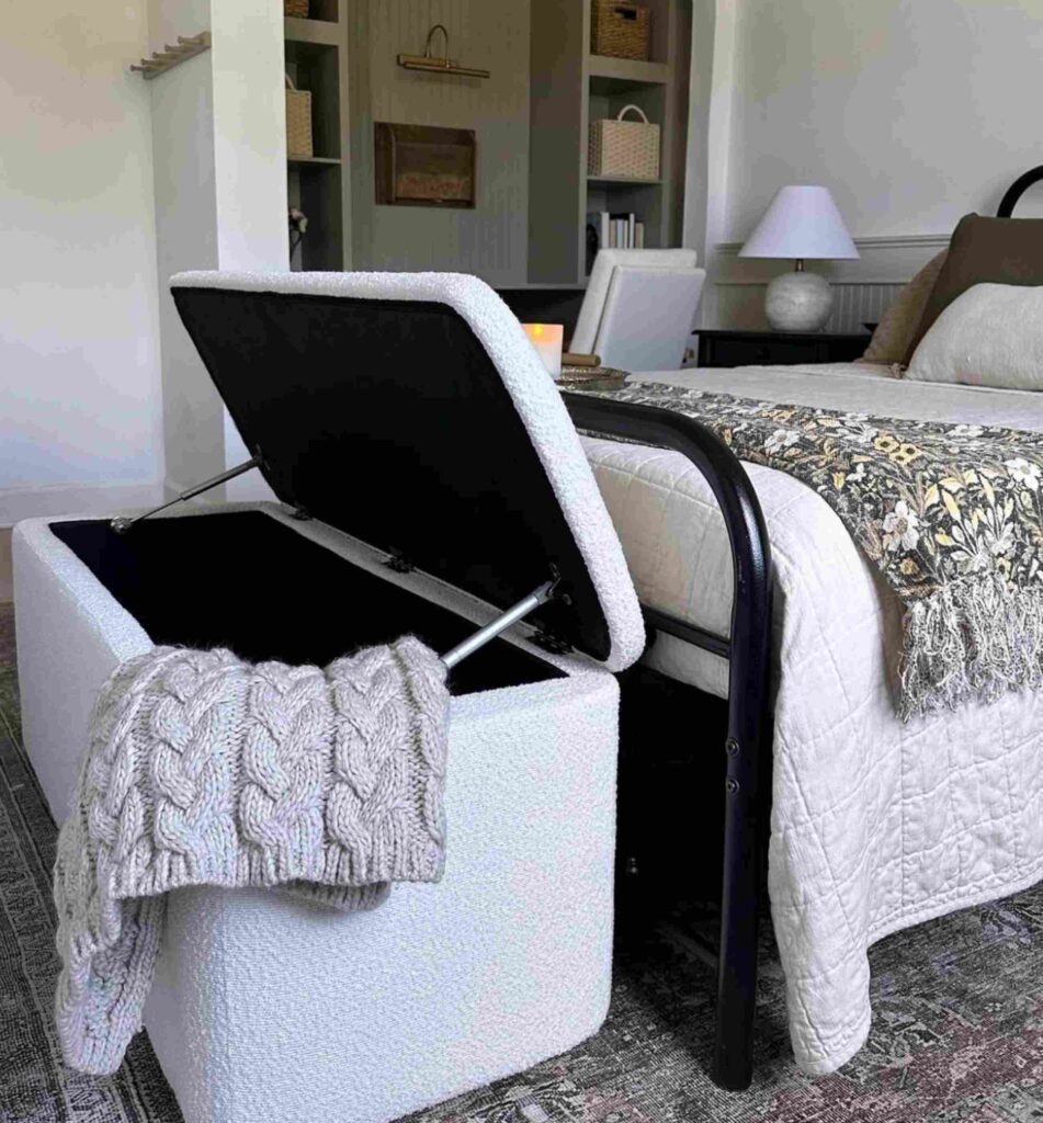 Tan storage bench at the end of a bed