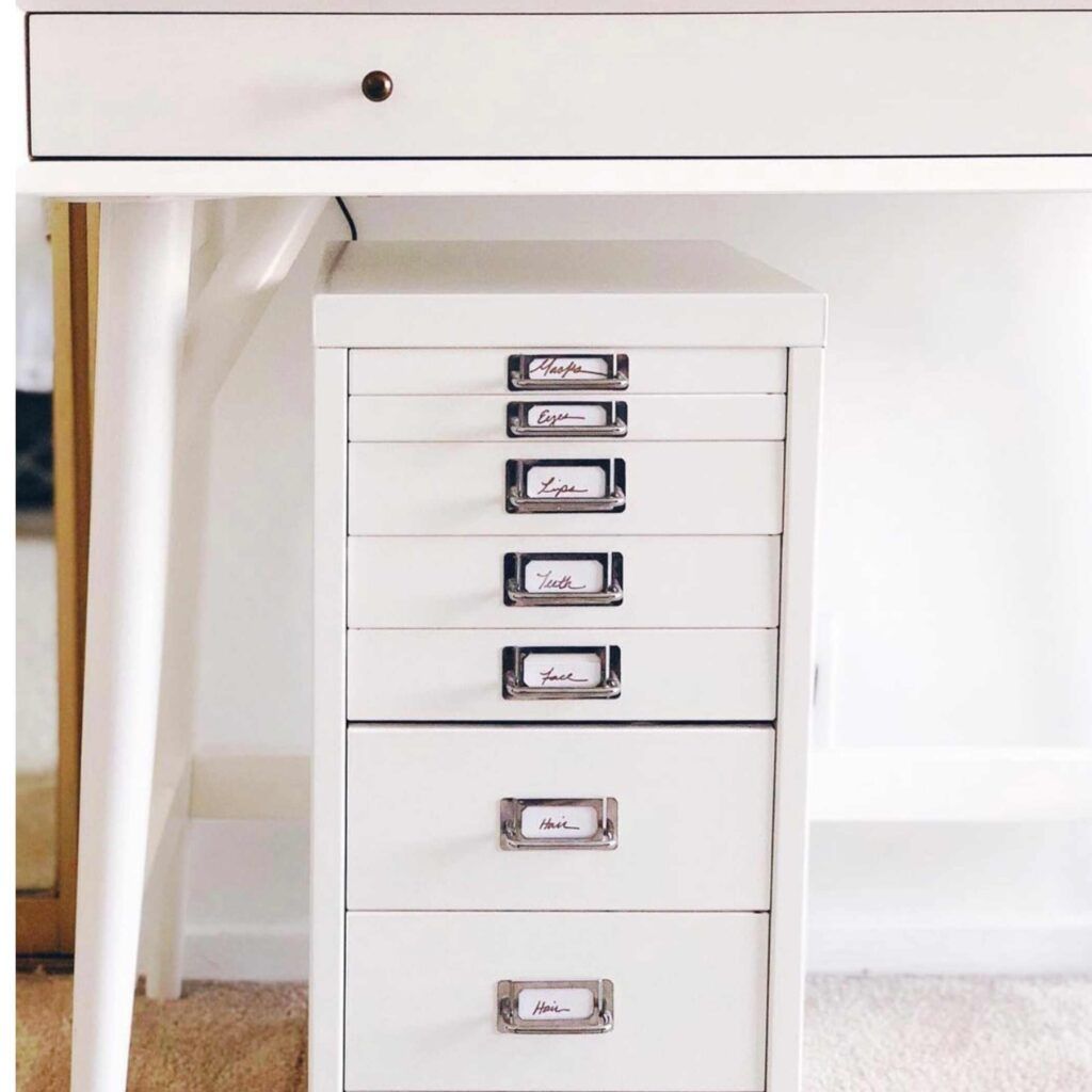 White file cabinet underneath a desk 