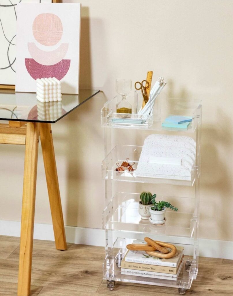 An acrylic caddy that has extra office supplies on each caddy shelf. 