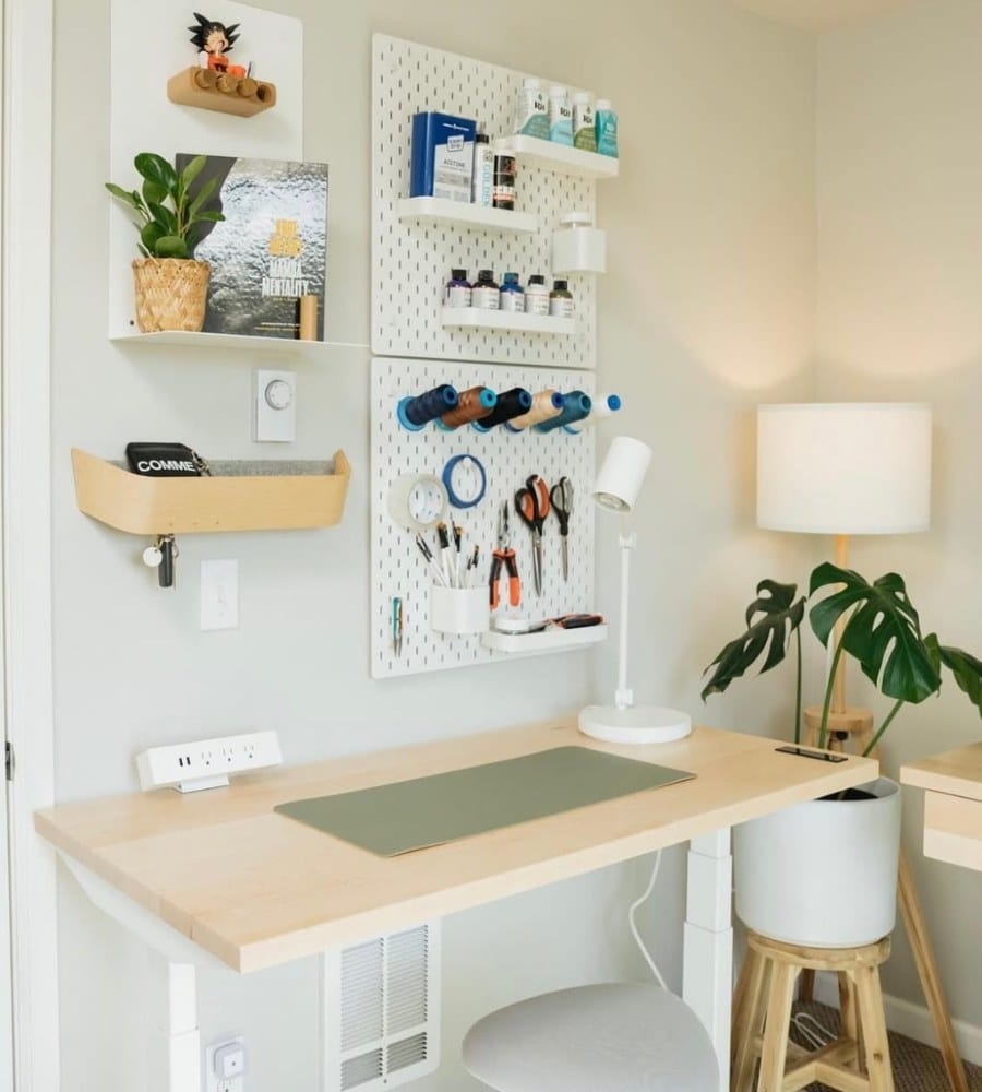 An office space that has a pegboard on the wall to store daily tools and utensils 