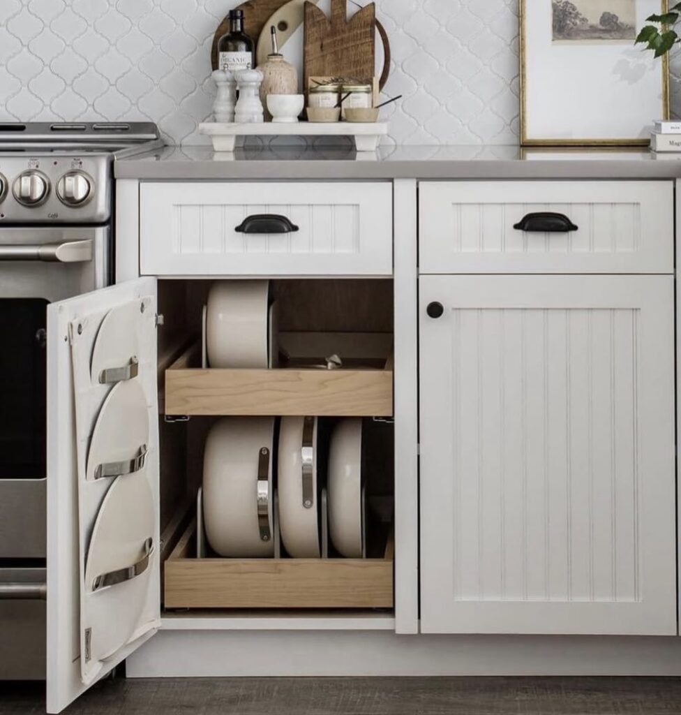 Pots and pans stored on a vertical pot organizer in a kitchen cabinet 