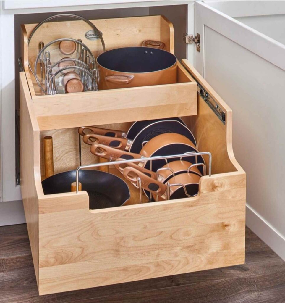 Pots and pans stored on pull out cabinet drawers with spacers for pots, pans, and lids. 