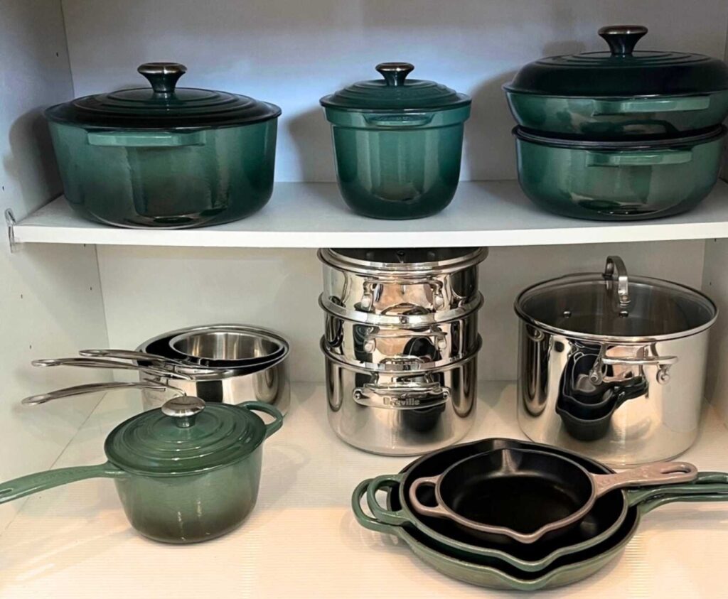 Pots and pans stacked in a kitchen cabinet