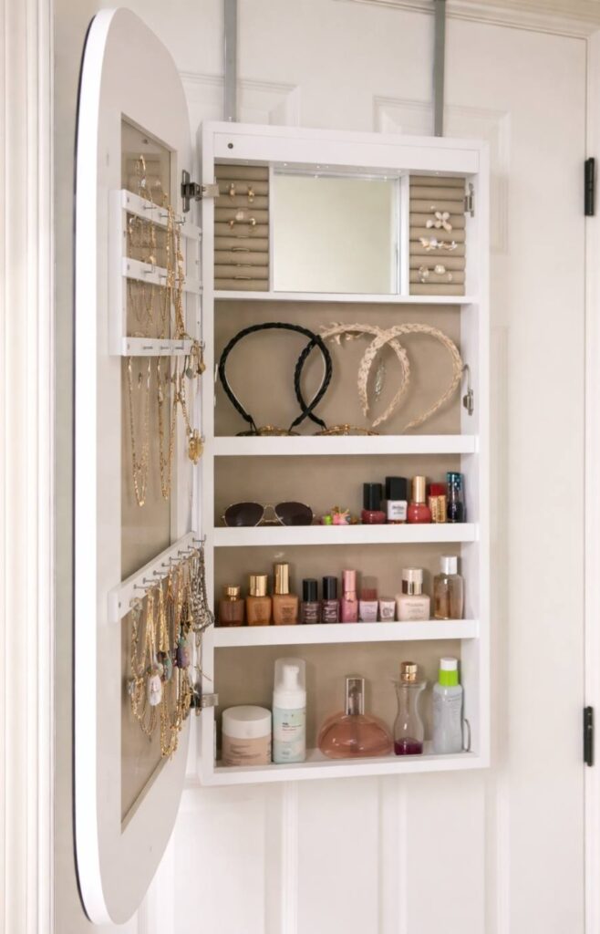 Picture of white over the door mirror jewelry cabinet in a small bedroom.  